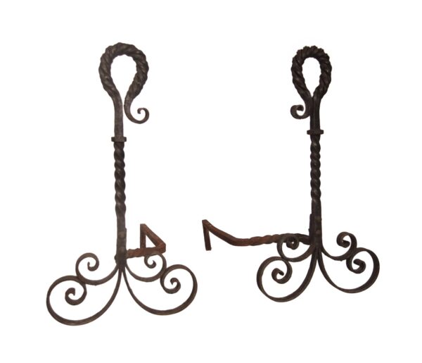 Pair of wrought iron andirons with twisted uprights, curled decorative bases, and a black finish.