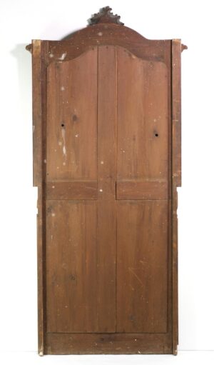 Tall antique wood-framed mirror with a Rococo carved crest and multiple vertical panels, shown from the back in a dark wood tone.