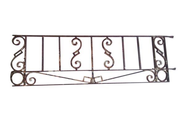 Antique wrought iron window guard with scrollwork and vertical bars, shown as a long rectangular panel with a rusted black finish.