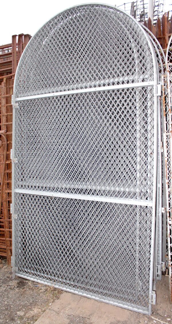 Arched woven iron window guard with a hinged frame and diamond mesh pattern.