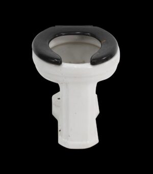Art Deco toilet bowl with a black seat and white porcelain body, shown from above with visible wear.