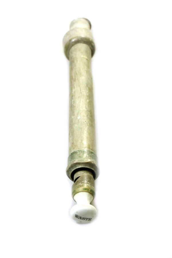 Antique brass waste tub pipe with a white ceramic end marked "WASTE."