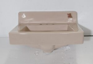 1950s pink porcelain sink with a rounded trapezoid basin and no hardware included.