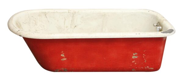 Antique clawfoot tub with a red cast iron exterior and white porcelain interior, shown in side view with visible surface wear and staining.