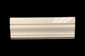 White ridged cap tile with a shiny crackled surface and visible age-related chips.