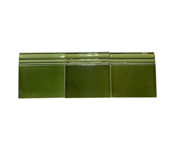 Set of three light green ceramic baseboard tiles with a shiny, slightly crackled surface and visible chips and scrapes from age.