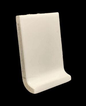 White ceramic inside corner baseboard tile with a curved profile and a glossy surface.