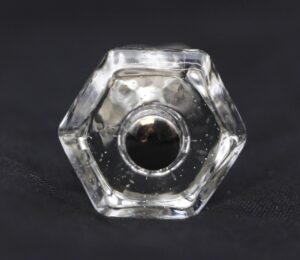 Clear hexagon glass cabinet knob shown in a front view, with the screw opening visible at the center.
