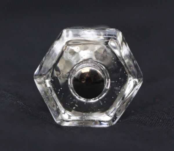 Clear hexagon glass cabinet knob shown in a front view, with the screw opening visible at the center.