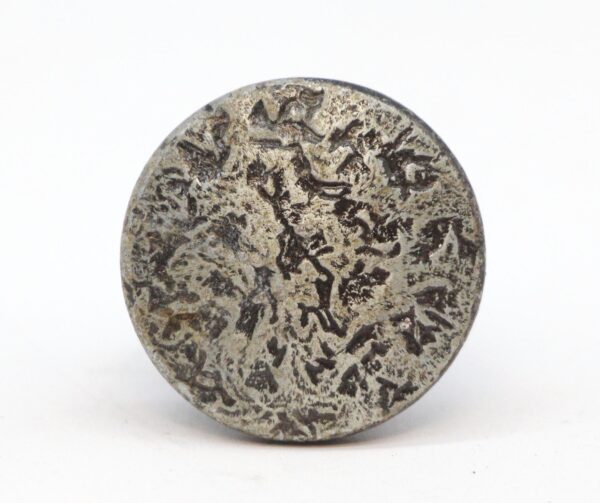 Round cast iron cabinet knob with a hammered surface and worn black and nickel finish, shown front on.