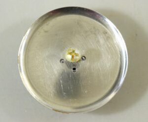Vintage concave cabinet knob with matching plate, shown from above with a central screw and two smaller screws visible.