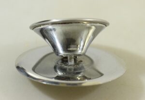 Vintage chrome drawer knob with matching plate, shown in close-up from the side.