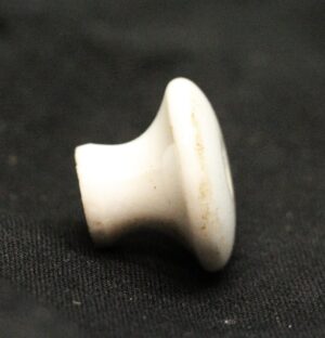 Round white ceramic drawer knob shown in profile, with visible age wear and an included screw mount.