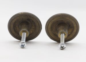 Pair of vintage brass drawer knobs shown from the back with mounting screws attached.