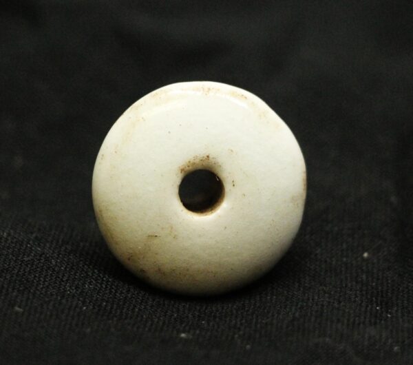 Round white ceramic drawer knob with a centered hole, shown in close-up against a dark background.