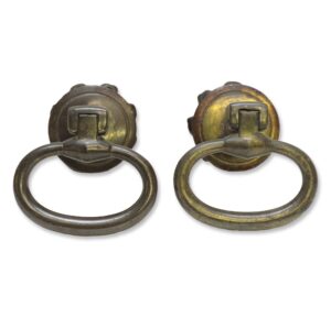Pair of cast iron drop ring drawer pulls shown as a pair, with a traditional design and visible patina finish on the backplates and rings.