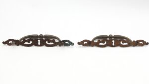 Pair of traditional brass keyhole drawer pulls with mounting screws, shown as a matching pair with one pull displaying a finish variation at the end.