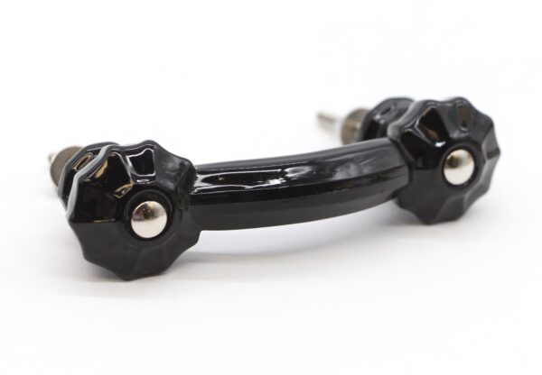 Black glass bridge drawer pull with fluted ends and chrome mounts shown in a close-up view.