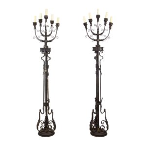 Pair of wrought iron floor candelabra lamps with five lights each, shown as a matching pair with foliate details and ornate scroll bases.