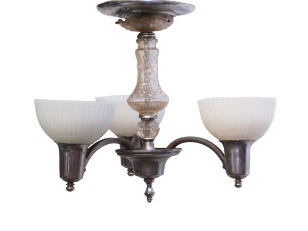 Art Deco three-light chandelier with white ribbed glass shades, a clear glass center column, and a chrome-plated base.