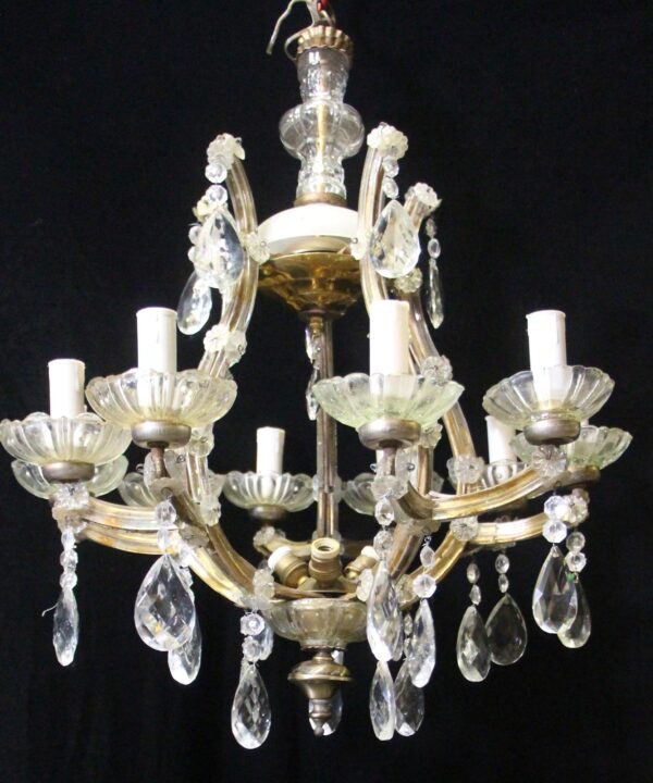 Marie Therese chandelier with 10 scrolling arms, candlestick sockets, and hanging crystal prisms.