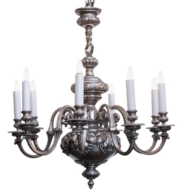 Silvered bronze nine-light chandelier with scrolling arms and candle-style sockets, shown in a frontal view.