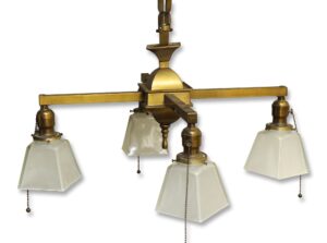 Traditional four-arm chandelier with antique brass frame and square frosted glass shades, shown with pull chains visible.