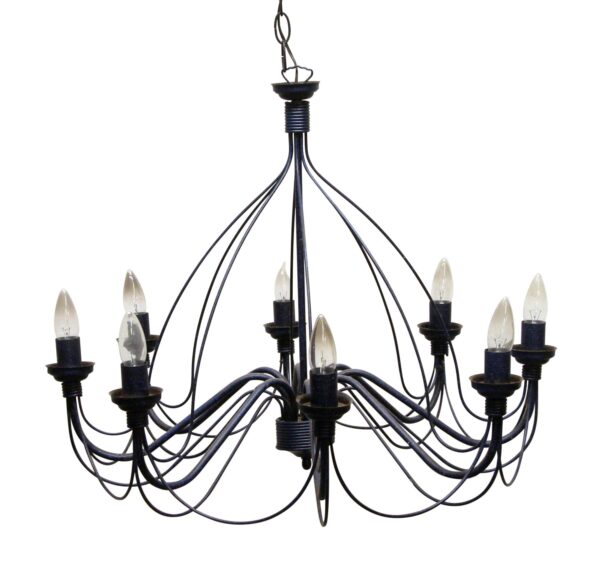 An eight-arm wrought iron chandelier with blue and black finish, arced wire drapes, and candlestick-style sockets with drip pans.