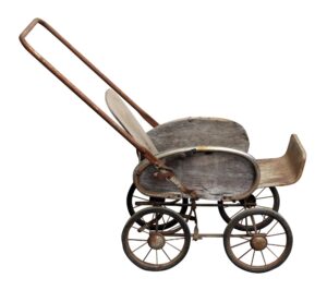 Vintage baby stroller with a medium wood tone body, steel frame, and four spoked wheels, shown in side view with an extended handle and curved seat.