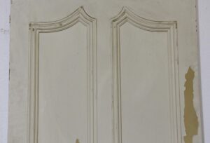 Distressed white closet door with two tall raised panels and curved molding, shown in a close-up of the front side.