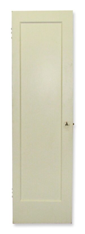 Narrow white wood closet door with one recessed panel visible on this side and hardware holes along the edge.