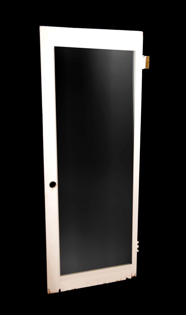 White wooden closet door with one full-length mirrored panel, shown at an angle with hinge cutouts visible on the edge.