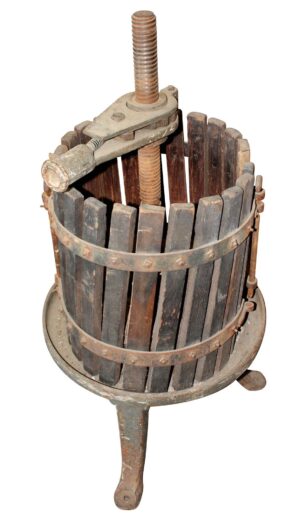 Old wine press with a cast iron base, vertical threaded screw, and dark wooden barrel slats arranged in a cylindrical frame.