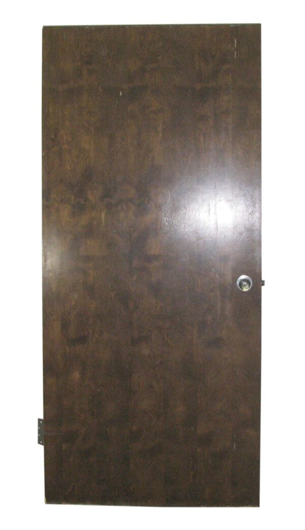 Vintage hardwood passage door shown front-on, with a single round knob and visible hinge hardware on one edge.