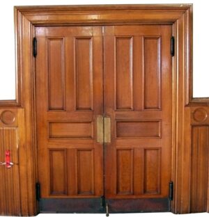 Double swinging wooden doors with five panels and center brass push plates, shown closed in a front view.