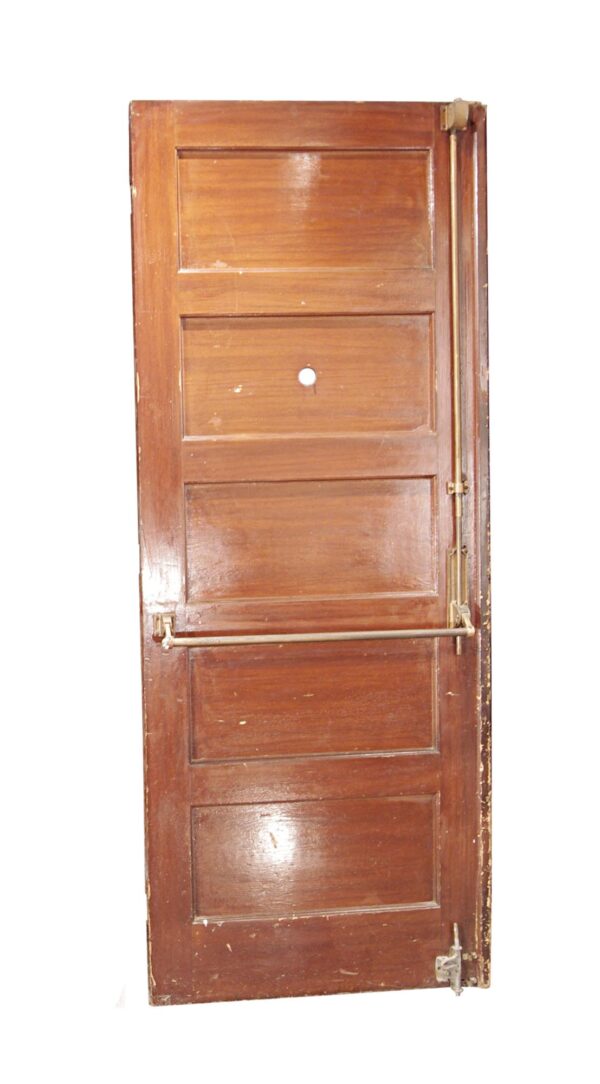 Wooden commercial door with five horizontal panels, a push bar, and visible hardware along the right edge.