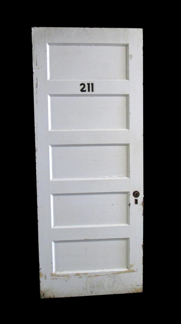 White five-panel wood apartment door with the number 211 on the upper center and a round knob on the right side, shown full length with visible wear along the edges and bottom.