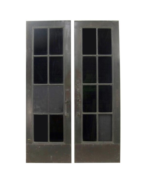 A pair of commercial double doors with eight-lite glass panels, shown closed and front-facing with a visible handle on one leaf.