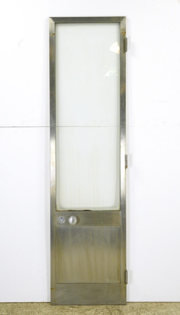 Vintage steel commercial door with a tall glass lite, a bottom panel, cylinder lock, and door knob, shown upright with hinges visible on the right side.