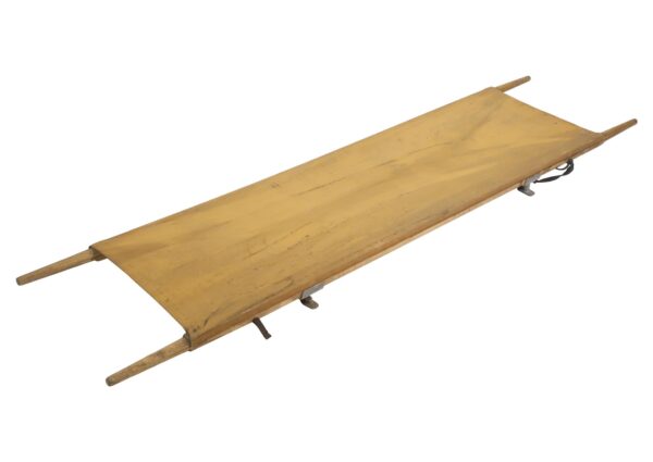 Tan canvas litter stretcher with wooden handles and metal supports shown diagonally, in fair condition.