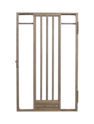1940s Art Deco bronze bank teller door with a central barred panel, side openings, and engraved “Next Window” lettering at the bottom.