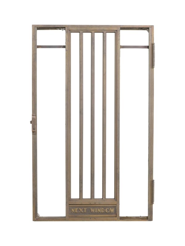 1940s Art Deco bronze bank teller door with a central barred panel, side openings, and engraved “Next Window” lettering at the bottom.