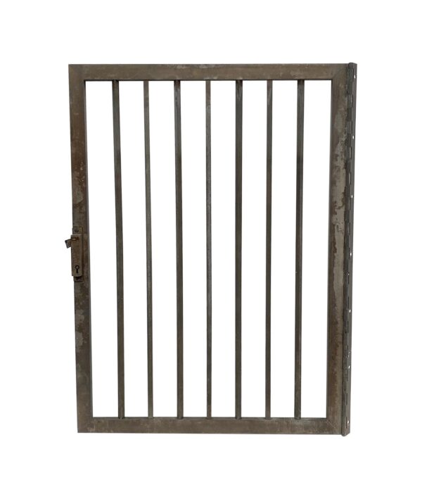 Bronze bank teller window gate with vertical bars and a latch, shown front on.