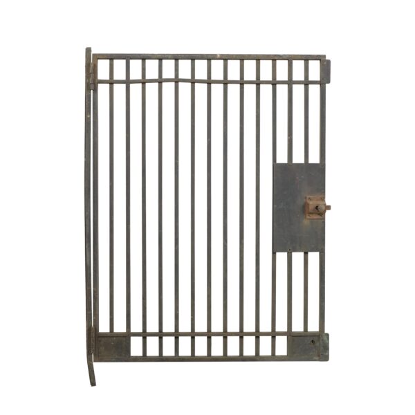 Antique bronze bank teller door with vertical bars, original hinge bracket, and a latch plate on the right side.