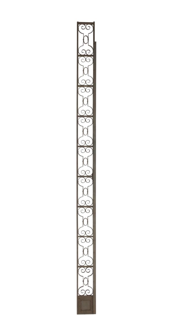 Tall wrought iron trim piece with repeating scrollwork and a small decorative panel at the bottom.