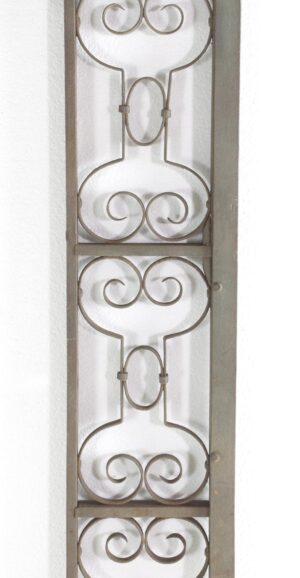Vertical wrought iron trim piece with scrolling openwork and horizontal bars, shown in a close-up view of the decorative panel.