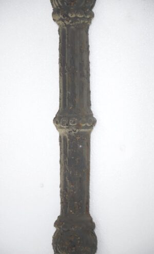 Close-up of a wrought iron baluster wall panel with a black finish and visible rust detail.