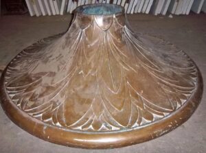 Ornate bronze base with a wide flared shape and carved leaf pattern, shown from above.