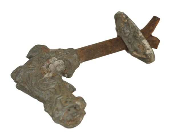 Cast iron handle with a nymph face at one end and an original rosette on the shaft, shown in close-up.