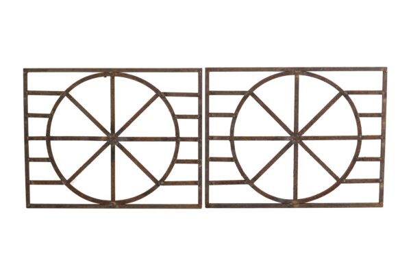 Pair of wrought iron panels with a wheel-like geometric pattern, shown as a rusted matching pair.